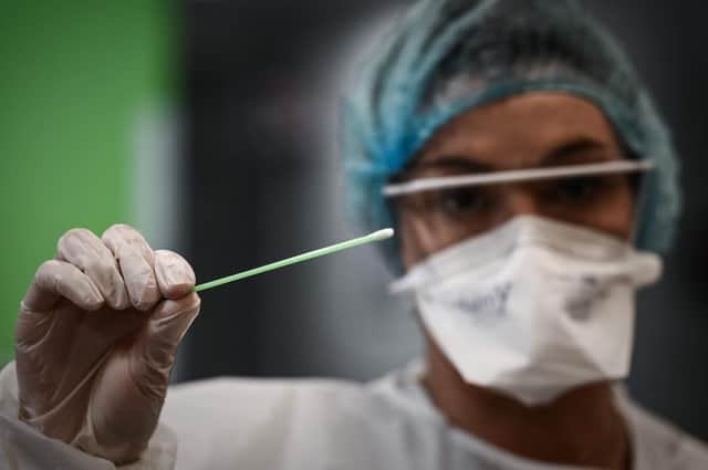 A medical professional holds a swab used for a rapid-result Covid-19 antigen test. Picture: Philippe Lopez via Getty Images