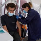 Vaccinator Suzanne Pozzo gives a vaccine to Omar Khalifa in a pop up tent at a drop in clinic outside Stenhousemuir Football Ground.  Picture date: Tuesday August 3, 2021.