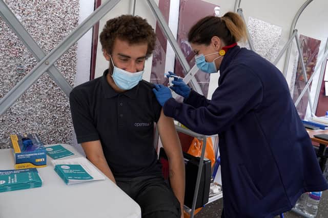 Vaccinator Suzanne Pozzo gives a vaccine to Omar Khalifa in a pop up tent at a drop in clinic outside Stenhousemuir Football Ground.  Picture date: Tuesday August 3, 2021.