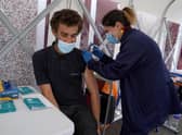 Vaccinator Suzanne Pozzo gives a vaccine to Omar Khalifa in a pop up tent at a drop in clinic outside Stenhousemuir Football Ground.  Picture date: Tuesday August 3, 2021.