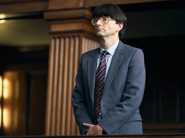 In a scene from Des, David Tennant portrays Dennis Nilsen during his trial for murder.