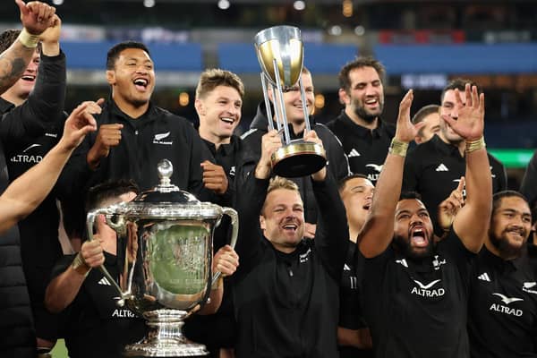 All Blacks captain Sam Cane, centre, lifts the Rugby Championship trophy while a team-mate hoists the larger Bledisloe Cup after New Zealand's decisive win over Australia at Melbourne Cricket Ground last year. (Photo by Cameron Spencer/Getty Images)