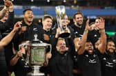 All Blacks captain Sam Cane, centre, lifts the Rugby Championship trophy while a team-mate hoists the larger Bledisloe Cup after New Zealand's decisive win over Australia at Melbourne Cricket Ground last year. (Photo by Cameron Spencer/Getty Images)