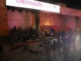 Firefighters and police rescue migrants from an immigration station in Ciudad Juarez, Chihuahua state on March 27, 2023, where at least 39 people were killed and dozens injured after a fire at the immigration station.  (Photo by HERIKA MARTINEZ/AFP via Getty Images)