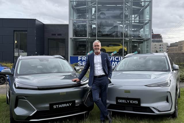 The dealership's new car sales manager, Brian Fraser, in front of the showroom's iconic tower.