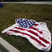 Empty chairs and an American flag blanket lie on the ground after a mass shooting at the Highland Park Fourth of July parade in downtown Highland Park. Photo: AP Photo/Nam Y. Huh.