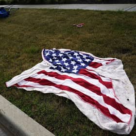 Empty chairs and an American flag blanket lie on the ground after a mass shooting at the Highland Park Fourth of July parade in downtown Highland Park. Photo: AP Photo/Nam Y. Huh.