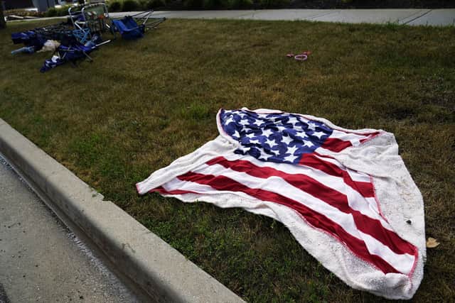 Empty chairs and an American flag blanket lie on the ground after a mass shooting at the Highland Park Fourth of July parade in downtown Highland Park. Photo: AP Photo/Nam Y. Huh.