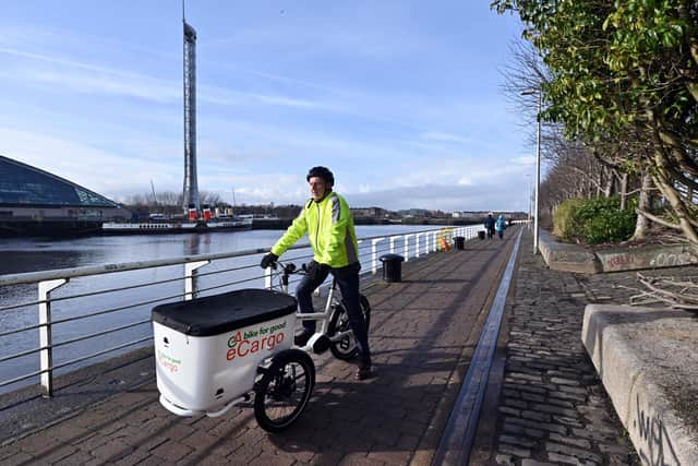 The Scotsman transport correspondent Alastair Dalton trying out an electric cargo bike on a cycle path beside the Clyde in Glasgow. Picture: John Devlin