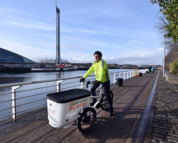 The Scotsman transport correspondent Alastair Dalton trying out an electric cargo bike on a cycle path beside the Clyde in Glasgow. Picture: John Devlin