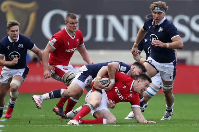 Scotland scrum-half Ali Price tackles Wales' wing Josh Adams as Jamie Ritchie, right, gets ready to move in.