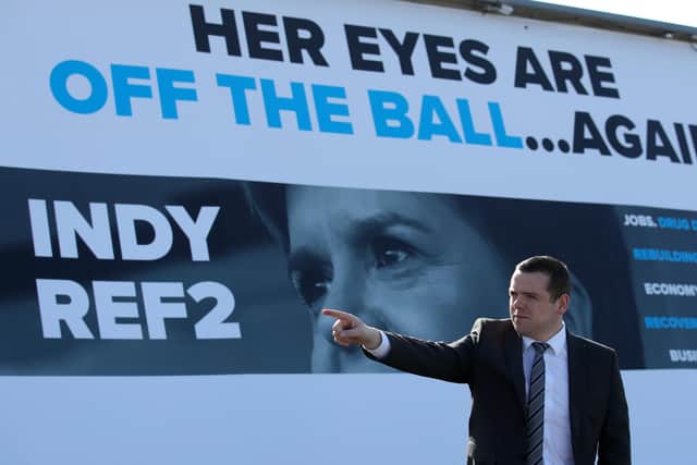 Scottish Conservative party leader Douglas Ross stands in front of a picture of First Minister Nicola Sturgeon as he launches an ad van campaign in Glasgow during campaigning for the Scottish Parliamentary election.