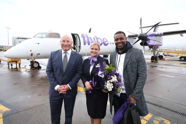 No name was provided for the Flybe crew member standing between Belfast City Airport chief executive Matthew Hall and first passenger Andre Squire. Picture: Kelvin Boyes