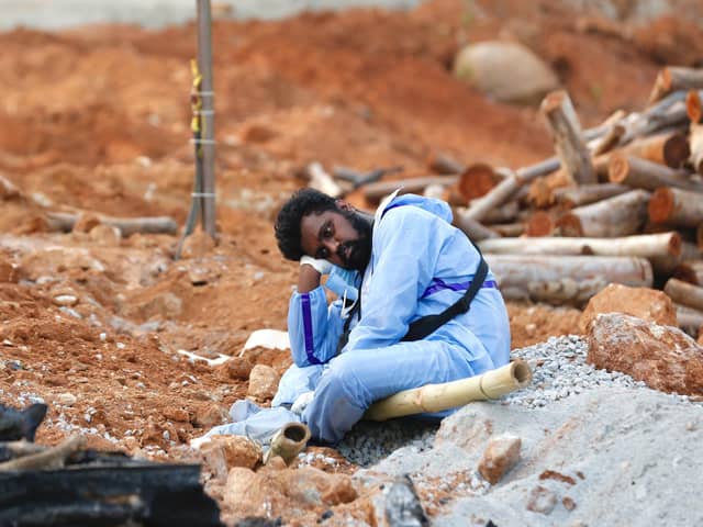 A man wearing PPE waits to take part in the funeral of a deceased relative in a new crematorium built to cope with victims of Covid-19 in Bengaluru, India (Picture: Abhishek Chinnappa/Getty Images)