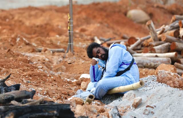 A man wearing PPE waits to take part in the funeral of a deceased relative in a new crematorium built to cope with victims of Covid-19 in Bengaluru, India (Picture: Abhishek Chinnappa/Getty Images)