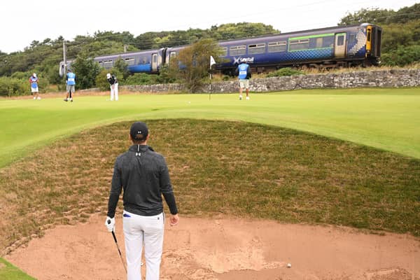 Jordan Spieth looks on from a bunker on the 11th hole as a train goes past during a practice round prior to The 152nd Open at Royal Troon. Picture: Ross Kinnaird/Getty Images.