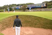Jordan Spieth looks on from a bunker on the 11th hole as a train goes past during a practice round prior to The 152nd Open at Royal Troon. Picture: Ross Kinnaird/Getty Images.