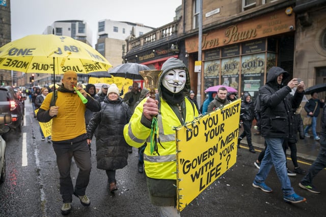 An activist holding a sign which says: "Do you trust your Govern'ment with your life?"