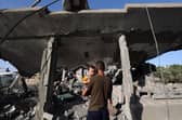 A Palestinian man holding a child looks on as children sit inside a house targeted in an Israeli strike at the Nuseirat camp for refugees in the central Gaza Strip. Picture: Eyad Baba/AFP via Getty Images
