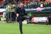 Celtic manager Brendan Rodgers kicks a ball back into the crowd at Tannadice - it was thrown on as apart of a protest by Celtic fans at ticket prices (Photo by Craig Foy / SNS Group)