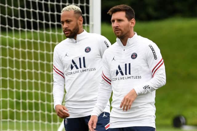 Paris Saint-Germain's Argentinian forward Lionel Messi and Paris Saint-Germain's Brazilian forward Neymar (L) take part in a training session at the Camp des Loges Paris Saint-Germain football club's training ground in Saint-Germain-en-Laye on August 19, 2021. (Photo by BERTRAND GUAY/AFP via Getty Images)