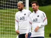 Paris Saint-Germain's Argentinian forward Lionel Messi and Paris Saint-Germain's Brazilian forward Neymar (L) take part in a training session at the Camp des Loges Paris Saint-Germain football club's training ground in Saint-Germain-en-Laye on August 19, 2021. (Photo by BERTRAND GUAY/AFP via Getty Images)