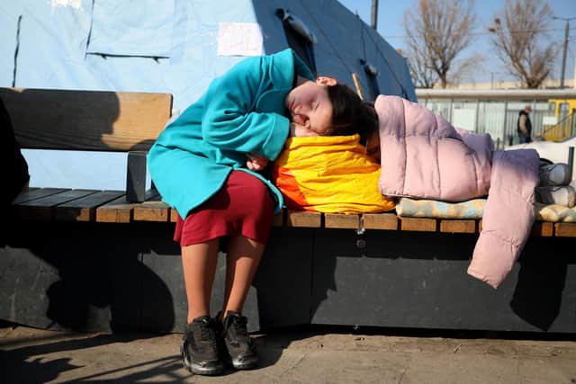 An evacuee girl sleeps outside railway station of western the Ukrainian city of Lviv, during Russia's military invasion launched on Ukraine. Photo by Aleksey Filippov / AFPGetty