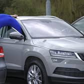 Contortionist Sally Miller attempts to get out of a parked car following research from Churchill Motor Insurance finding that drivers have just 30cm space to get in and out of parked cars. Photo: Paul Marriot/PA