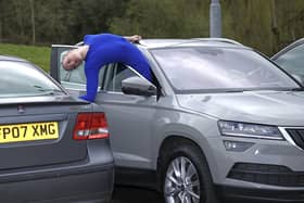 Contortionist Sally Miller attempts to get out of a parked car following research from Churchill Motor Insurance finding that drivers have just 30cm space to get in and out of parked cars. Photo: Paul Marriot/PA