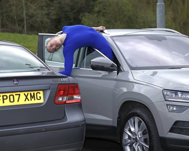Contortionist Sally Miller attempts to get out of a parked car following research from Churchill Motor Insurance finding that drivers have just 30cm space to get in and out of parked cars. Photo: Paul Marriot/PA