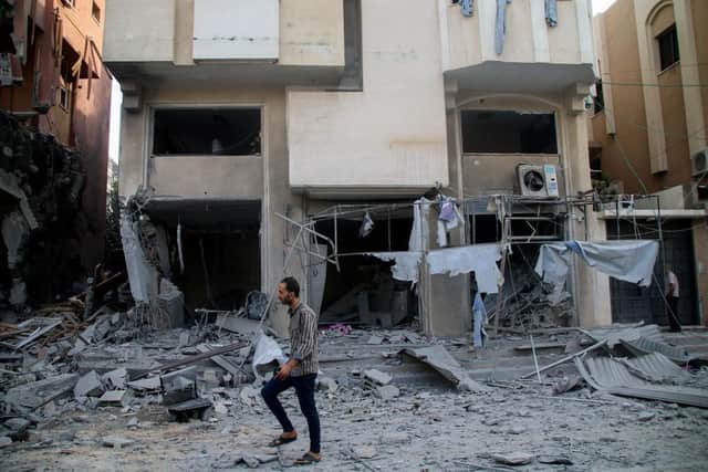 Palestinian citizens inspect damage to their homes caused by Israeli airstrikes in Gaza.