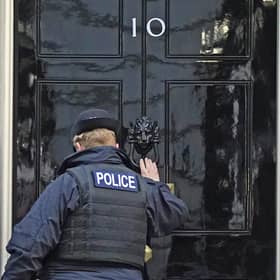 A police officer knocks on the door of the Prime Minister's official residence in Downing Street. Picture: PA