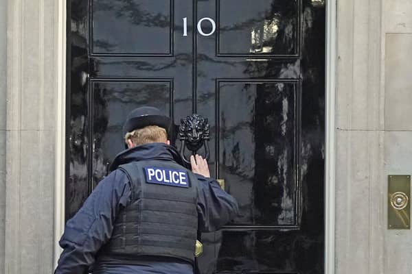 A police officer knocks on the door of the Prime Minister's official residence in Downing Street. Picture: PA