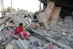 Boys sit amongst the rubble of a house in Rafah, Gaza, following Israeli air strikes this week.