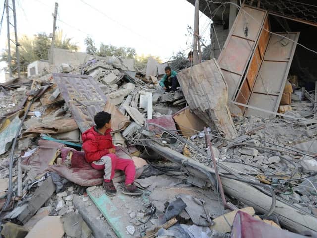 Boys sit amongst the rubble of a house in Rafah, Gaza, following Israeli air strikes this week.