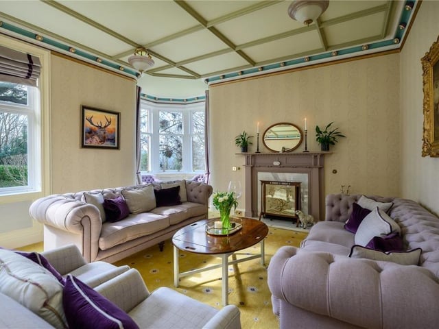The drawing room has large south facing windows, decorative ceiling, glazed turret alcove, and a large fireplace.
