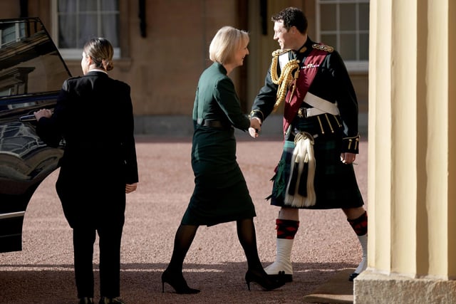 Outgoing Prime Minister Liz Truss, with her husband Hugh O'Leary, is greeted by King Charles III's equerry, Lieutenant Colonel Johnny Thompson, as she arrives at Buckingham Palace, London, for an audience with King Charles III to formally resign as PM.
