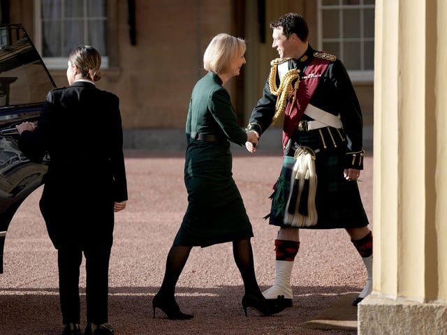 Outgoing Prime Minister Liz Truss, with her husband Hugh O'Leary, is greeted by King Charles III's equerry, Lieutenant Colonel Johnny Thompson, as she arrives at Buckingham Palace, London, for an audience with King Charles III to formally resign as PM.