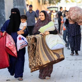 Palestinian women and children flee yesterday in the aftermath of an Israeli air strike on Rafah in the southern Gaza Strip sparked by Hamas attacks on Israel last weekend (Picture: Said Khatib/AFP via Getty Images)