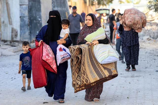 Palestinian women and children flee yesterday in the aftermath of an Israeli air strike on Rafah in the southern Gaza Strip sparked by Hamas attacks on Israel last weekend (Picture: Said Khatib/AFP via Getty Images)