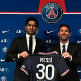 PSG's Qatari President Nasser Al-Khelaifi poses alongside Lionel Messi as he holds-up his number 30 shirt during a press conference.