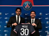PSG's Qatari President Nasser Al-Khelaifi poses alongside Lionel Messi as he holds-up his number 30 shirt during a press conference.