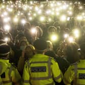 People in the crowd turn on their phone torches as they gather in Clapham Common, London