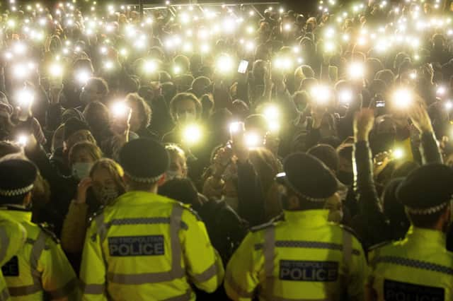 People in the crowd turn on their phone torches as they gather in Clapham Common, London