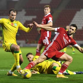 Hibs striker Christian Doidge tussles with Aberdeen midfielder Connor McLennan at Pittodrie.