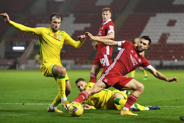 Hibs striker Christian Doidge tussles with Aberdeen midfielder Connor McLennan at Pittodrie.