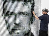 Artist Joe Black adds the finishing touches to a portrait of David Bowie made from over 8,500 guitar plectrums, commissioned by Sky Arts to celebrate Bowie topping a new definitive list of Britain's 50 most influential artists of the past 50 years