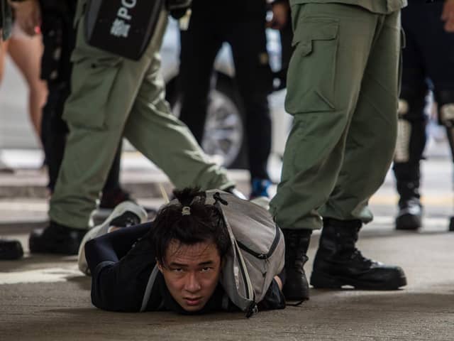 Riot police detain a man as they clear protesters taking part in a rally against a new national security law in Hong Kong on July 1 (Picture: dale de la Rey/AFP via Getty Images)