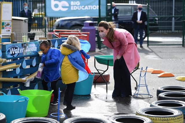 The Duchess of Cambridge talks with a child in the water area of the playground during a visit to School 21 in Stratford, east London (Photo: Justin Tallis/PA Wire).
