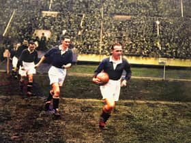 A colourised version of a black and white image showing Scotland captain Jimmy McMullan leading his team out at Wembley in 1928